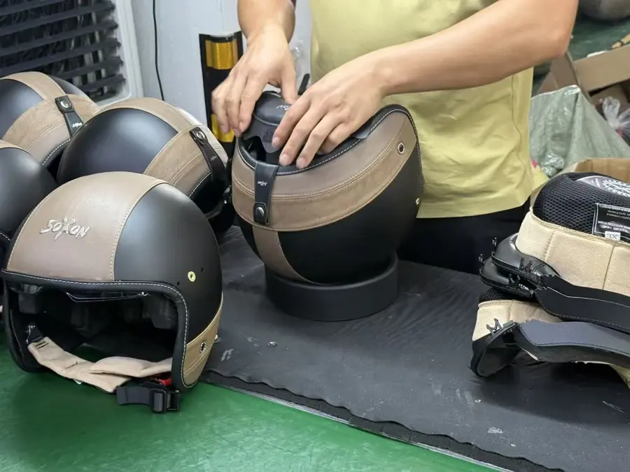 Hands working on a SOXON Urban helmet at the factory workbench